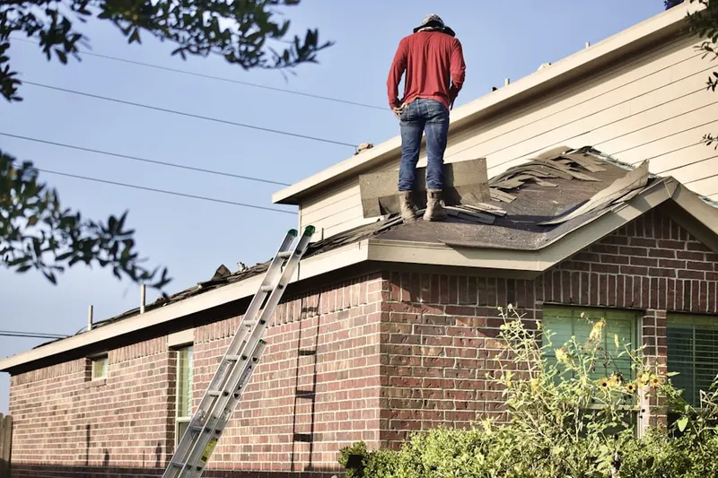 Professional roofer working on a residential roof in Ozark
